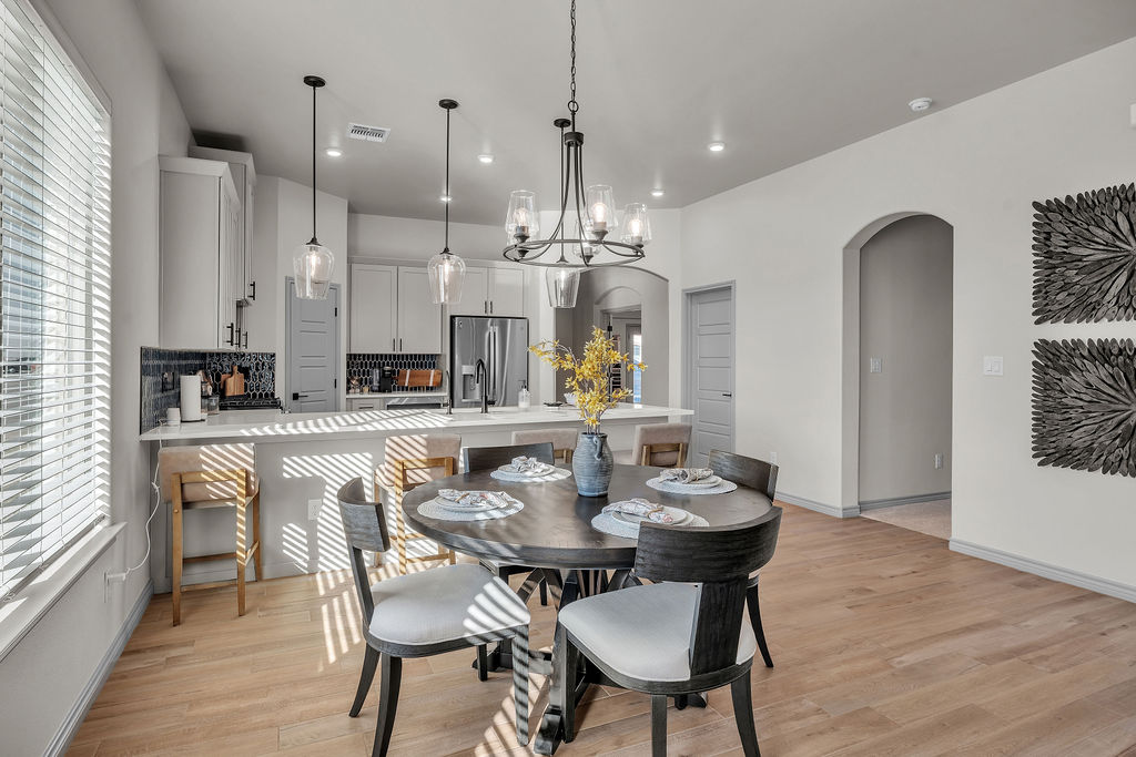 Silverleaf Homes — Open-concept kitchen and dining with designer lighting